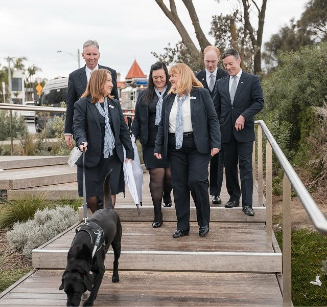 funeral directors with dog walking down stairs