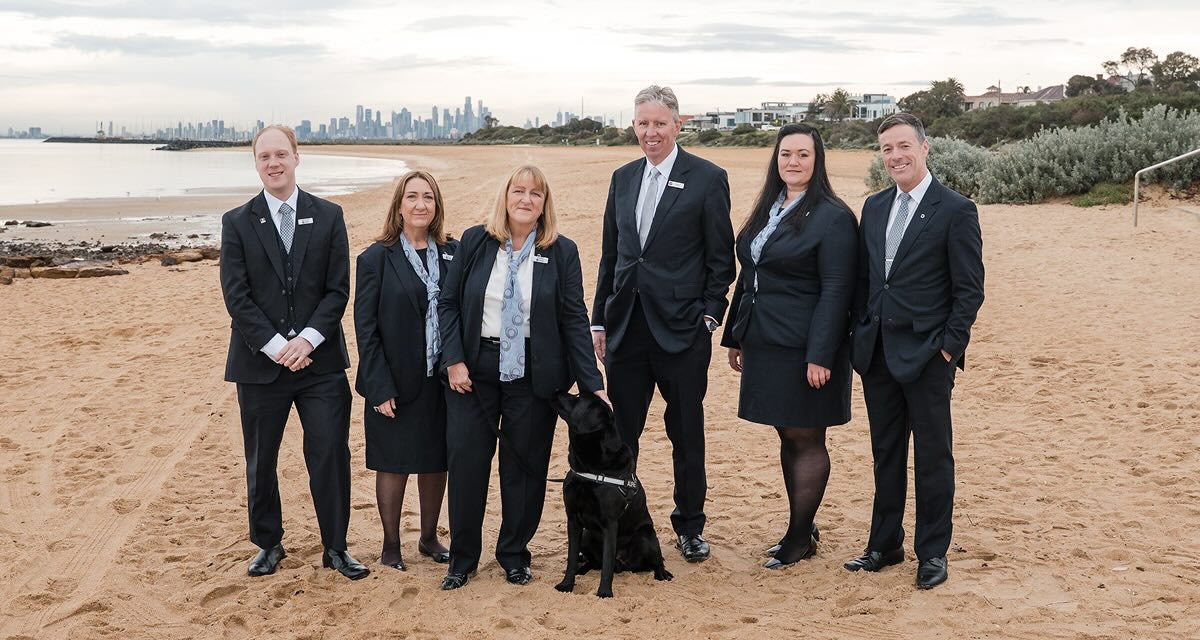 funeral directors with dog on a beach